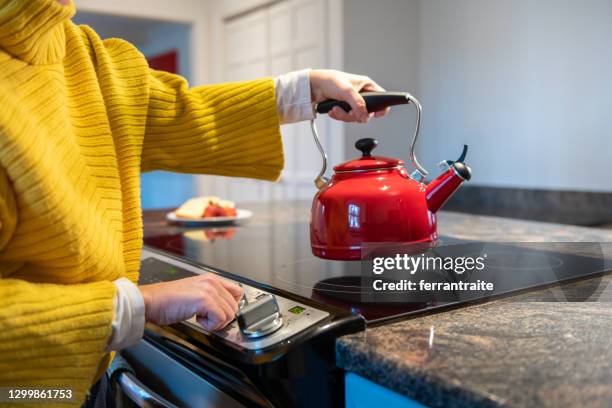 frau bereitet einen tee zu - herde stock-fotos und bilder