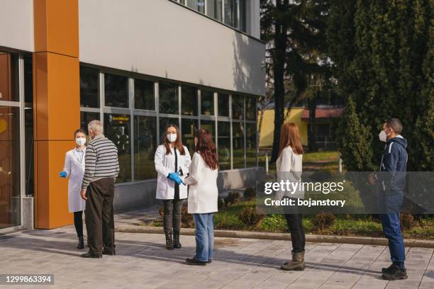 waiting for coronavirus vaccination - people queue mask stock pictures, royalty-free photos & images