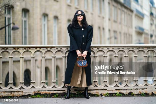 Fashion blogger Xiayan wears sunglasses from Bottega Veneta, a black wool long coat with shoulder pads from Lovechild, a gray tank top from...