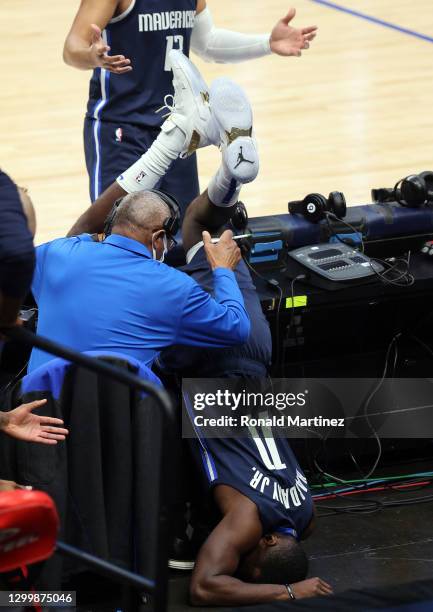 Tim Hardaway Jr. #11 of the Dallas Mavericks falls over the scorer's table during play against the Phoenix Suns in the first quarter at American...