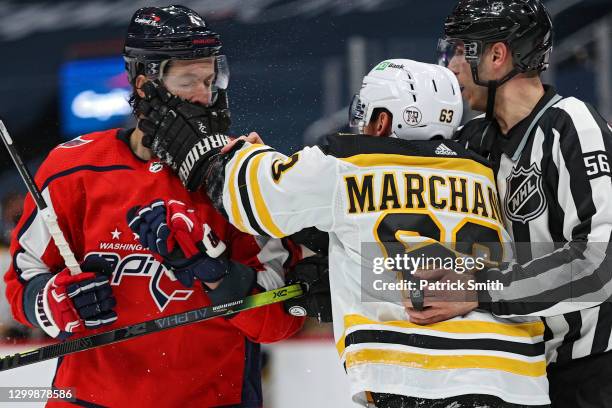 Brad Marchand of the Boston Bruins pushes Brenden Dillon of the Washington Capitals in the face during the third period at Capital One Arena on...