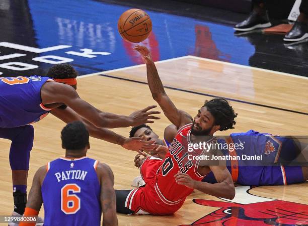 Coby White of the Chicago Bulls passes over Mitchell Robinson of the New York Knicks after battling for a loose ball with RJ Barrett at the United...