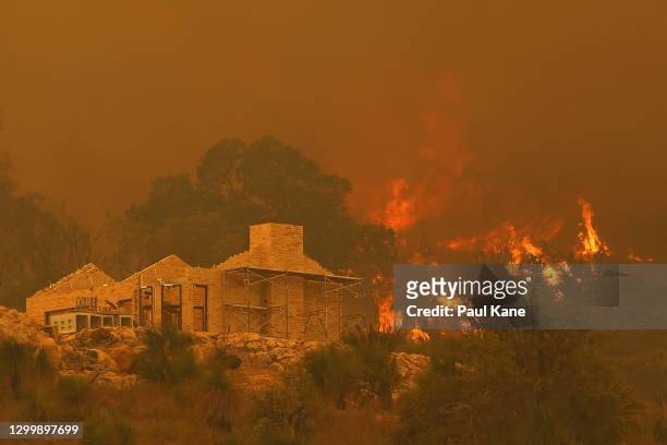 Flames surround a property under construction off Copley Road in Upper Swan on February 02, 2021 in Perth, Australia. Up to 30 homes are feared lost...