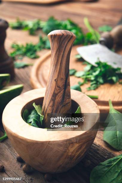 mortar and pestle with fresh herbs - mortar and pestle stock pictures, royalty-free photos & images