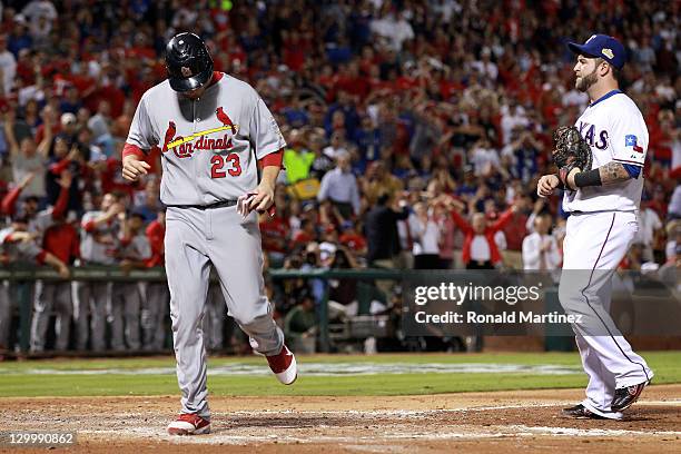 David Freese of the St. Louis Cardinals scores in the fourth inning after a throwing error by Mike Napoli of the Texas Rangers during Game Three of...