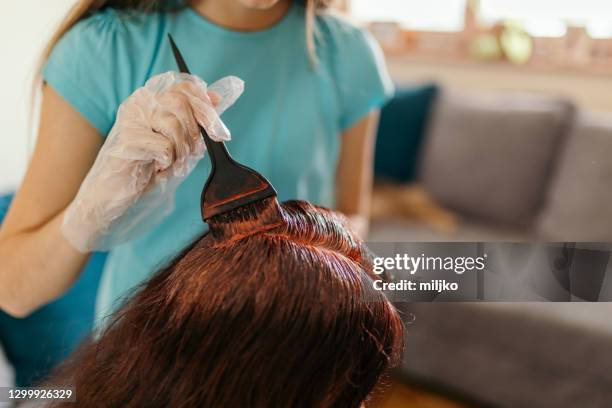 figlia che tinge i capelli delle madri a casa - dyes foto e immagini stock