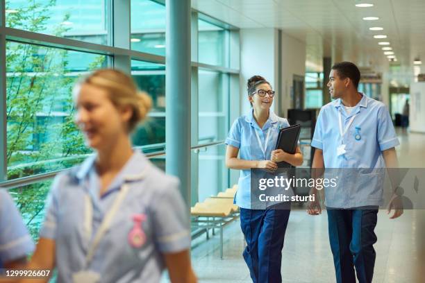 junge krankenschwestern auf der station - nhs nurse stock-fotos und bilder