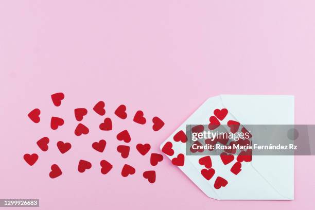 blank envelope full of red hearts shapes paper against pink background - ラブレター ストックフォトと画像