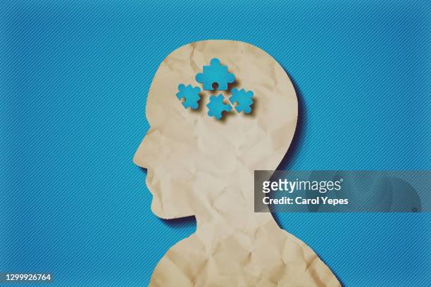paper head with puzzle pieces-autism concept.blue background - souvenirs photos et images de collection