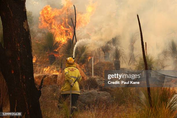 Fire crews control bush fires as they approach properties on Copley Road in Upper Swan on February 02, 2021 in Perth, Australia. The Rapid Damage...