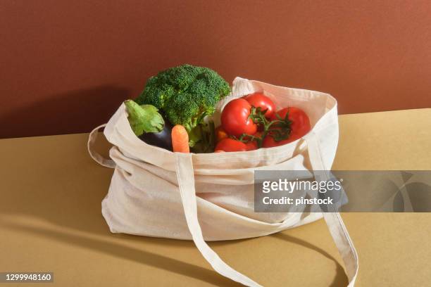 wiederverwendbare einkaufstasche mit frischem gemüse - shopping bag stock-fotos und bilder