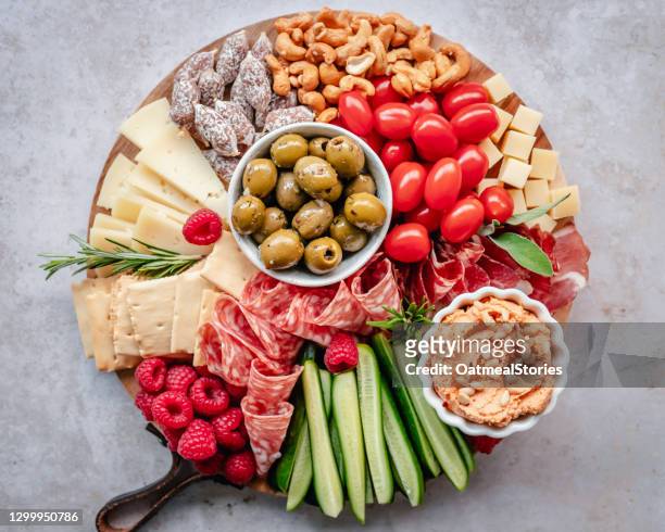 charcuterie and cheese platter with hummus, nuts, fruit and vegetables - cutting board stock pictures, royalty-free photos & images