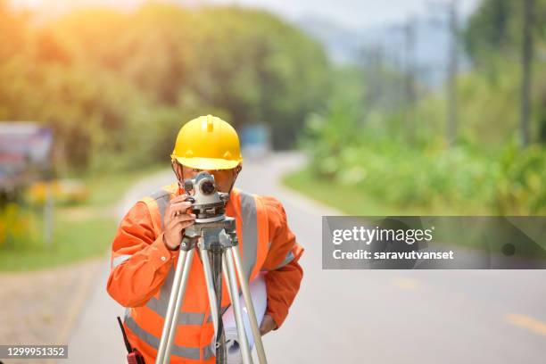 surveyor standing by a road working, thailand - geodesy stock pictures, royalty-free photos & images