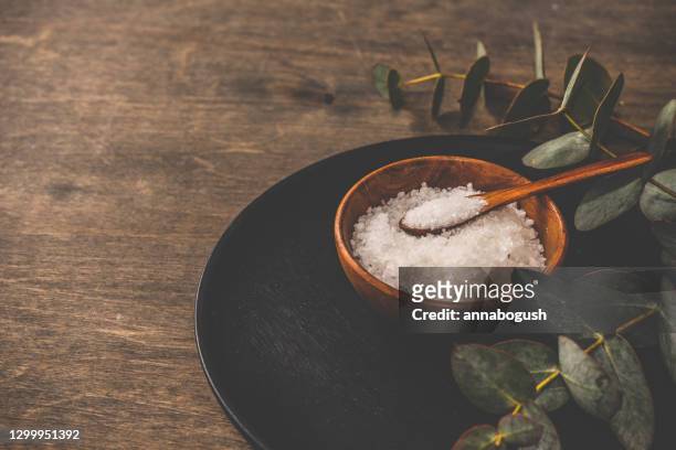 bowl of rock salt with fresh eucalyptus on a wooden table - bath salt stock pictures, royalty-free photos & images