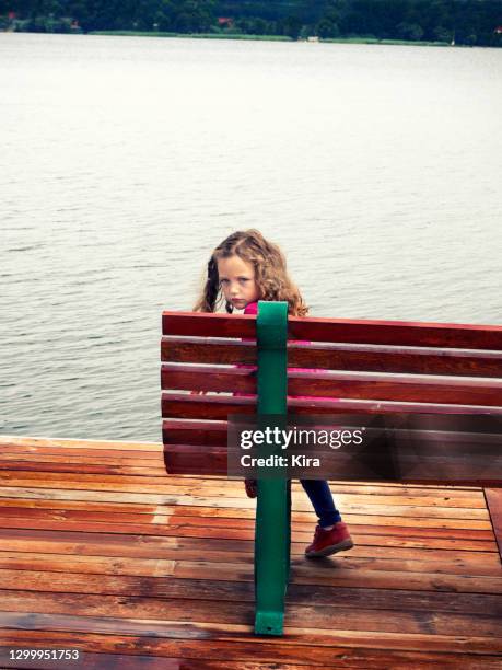 rear view of a girl sitting on a bench looking over her shoulder, poland - sulking stock pictures, royalty-free photos & images