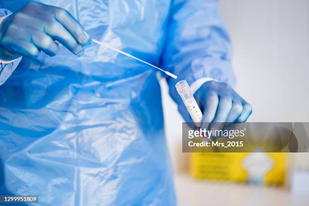 close-up of a doctor putting a pcr test swab into a tube - coronavirus stock pictures, royalty-free photos & images