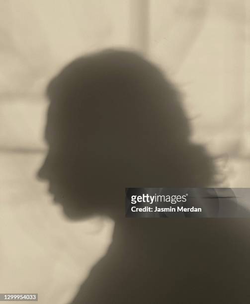 unknown female person silhouette shadow portrait sideview on wall - victim silhouette stock pictures, royalty-free photos & images