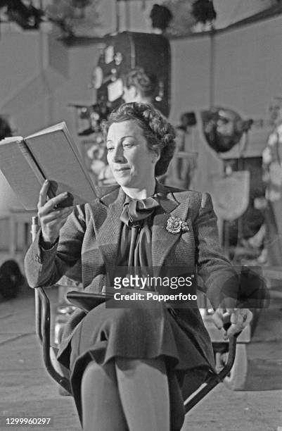 Argentine born actress Martita Hunt , dressed in character as Mrs Lindley, reads a book on set during production of the film 'The Seventh Survivor'...