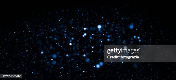 blue defocused lights and particles abstract background - defocussed lights stock pictures, royalty-free photos & images