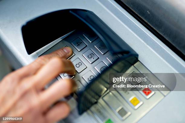 a person withdrawing money from an atm machine. - marcar el número de identificación personal fotografías e imágenes de stock