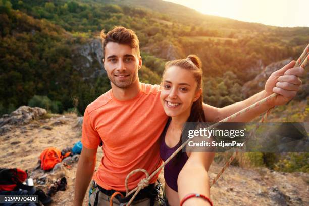 jong paar dat een selfie neemt alvorens te beklimmen - extreme sports stockfoto's en -beelden