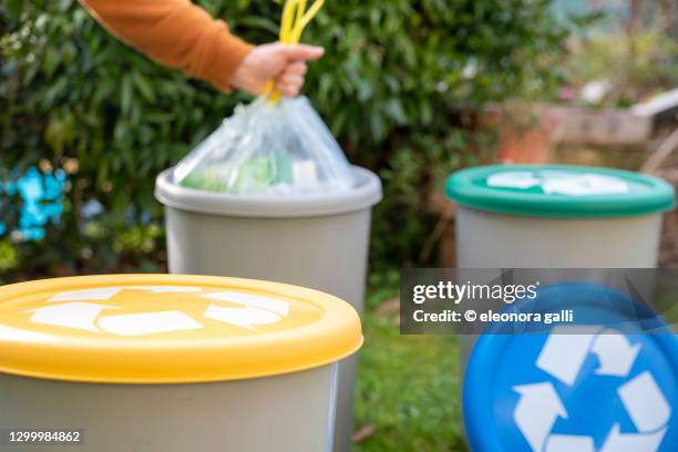 woman recycles in the recycling bin - rifiuto foto e immagini stock