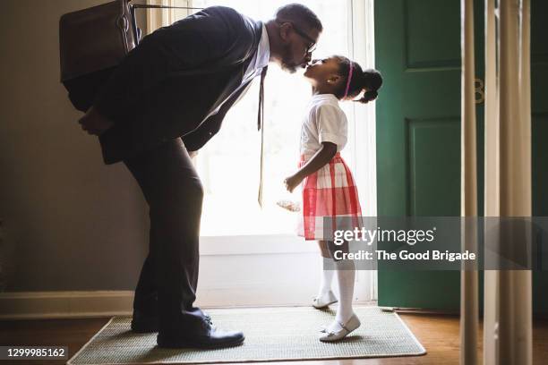 father kissing daughter goodbye as he leaves for work - bending over in skirt stock-fotos und bilder
