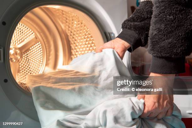 woman uses dryer to dry laundry - dryer stock-fotos und bilder