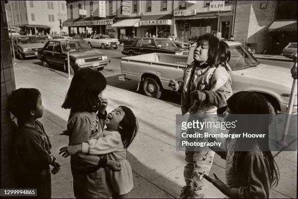 View of a group of children playing on a sidewalk in Chinatown, Oakland, California, 1989.