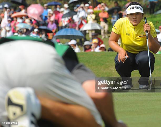 Amy Yang of South Korea lines up a putt with her caddie on the eigth green during the forth round of the Sunrise LPGA Taiwan Championship golf...