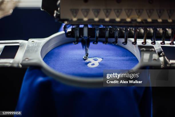 close up of embroidery machine head with blue fabric - embroidery stockfoto's en -beelden