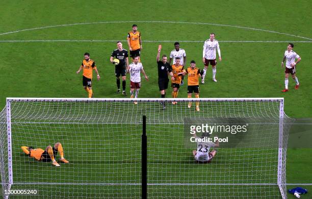 Referee, Craig Pawson shows David Luiz of Arsenal a red card as Willian Jose of Wolverhampton Wanderers lays injured inside the box during the...