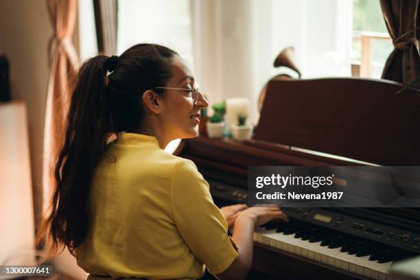 young woman pianist composing music in her room at home - 1987 25-35 stock pictures, royalty-free photos & images