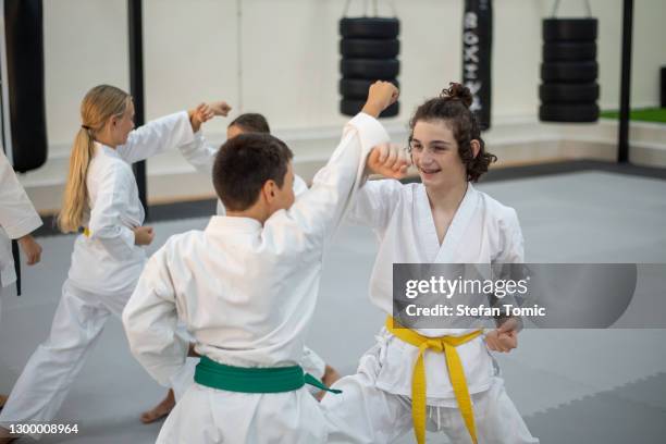 caucasian kids in kimono practicing karate in a sports gym. martial arts training session - karate stock pictures, royalty-free photos & images