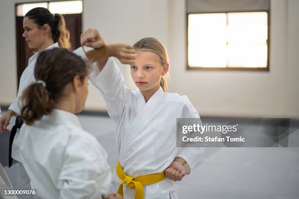 caucasian teenage kids in kimono practicing karate in a sports gym. martial arts training session - yellow belt stock pictures, royalty-free photos & images