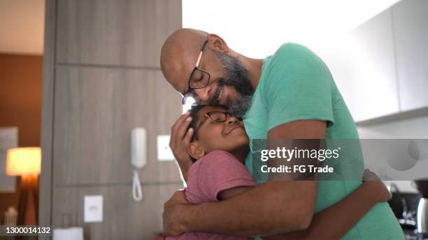 pai abraçando o filho em casa - filho família - fotografias e filmes do acervo