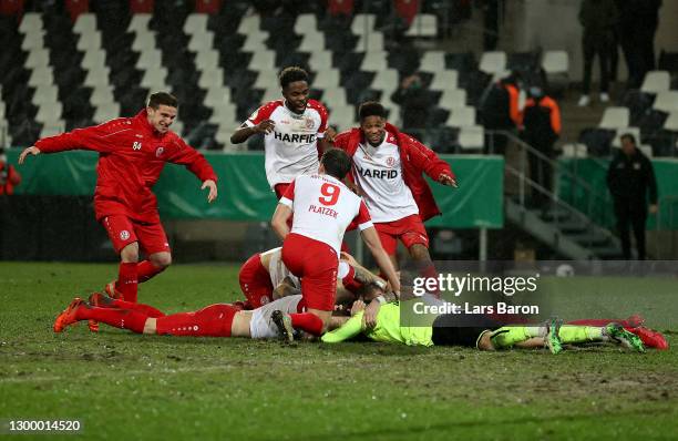 Players of Rot-Weiss Essen celebrate as they congratulate Daniel Davari of Rot-Weiss Essen following their sides victory after the DFB Cup Round of...