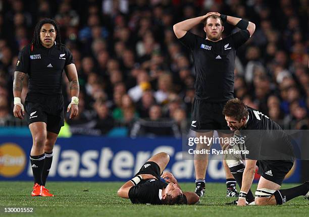 Richie McCaw of the All Blacks talks to an injured Aaron Cruden of the All Blacks during the 2011 IRB Rugby World Cup Final match between France and...