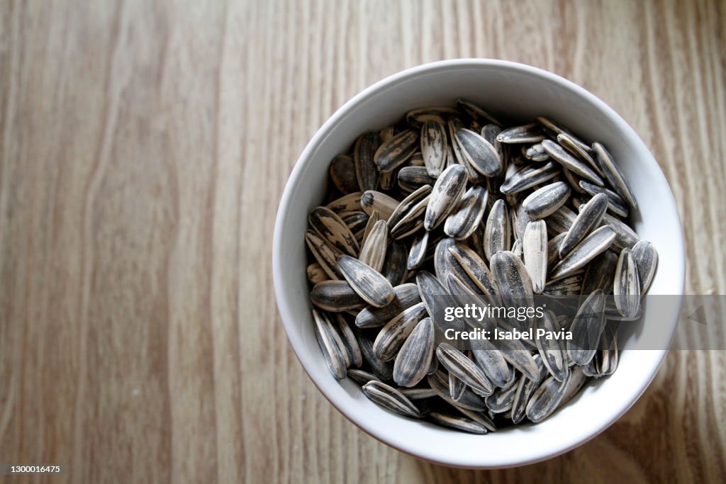 Bowl of sunflower seeds on wooden table