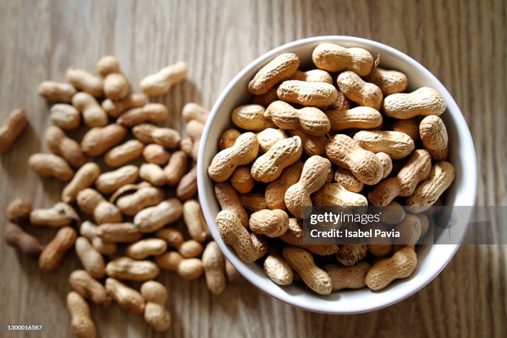 Bowl of peanuts on wooden table
