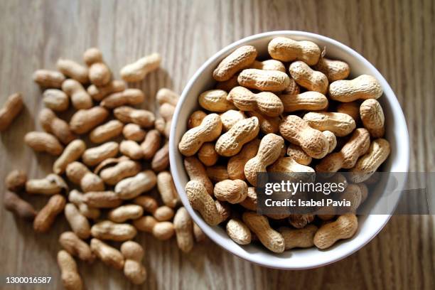 bowl of peanuts on wooden table - peanuts - fotografias e filmes do acervo