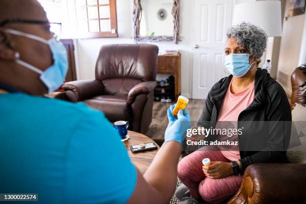 senior black woman und nurse home healthcare besuch - medicaid stock-fotos und bilder