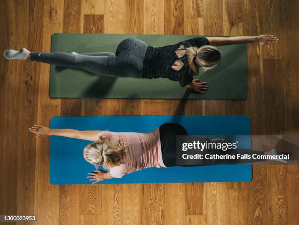 top down image of two woman on yoga mats in the 'superman' pose - 飛行機のまね ストックフォトと画像
