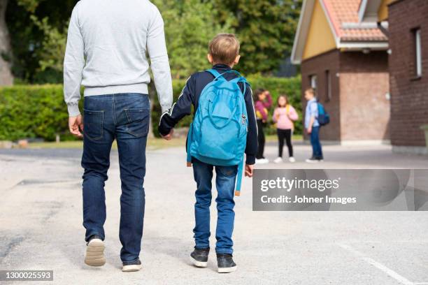 father taking boy to school - schulkinder eltern stock-fotos und bilder