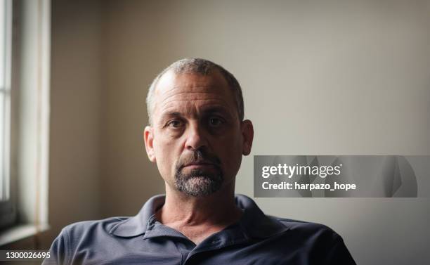 side lit portrait of a man sitting by a window. - akter bildbanksfoton och bilder