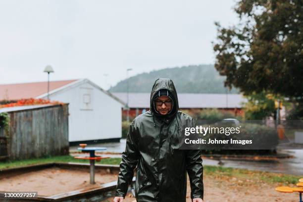 man walking in rainy weather - schaukel regen stock-fotos und bilder