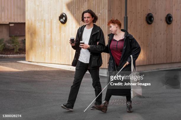 visually impaired woman walking with male friend - blind man ストックフォトと画像