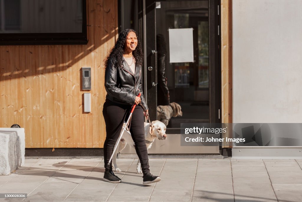 Visually impaired woman walking with guide dog