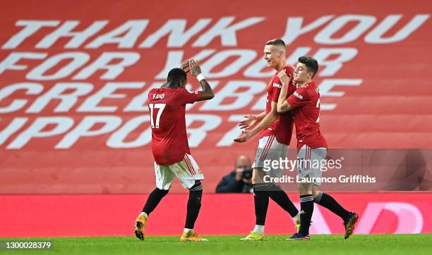 Scott McTominay of Manchester United celebrates with team mates Fred and Daniel James after scoring their side's sixth goal during the Premier League...