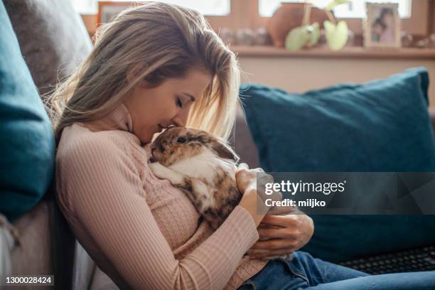 hermosa mujer joven y su mascota conejita - mascota fotografías e imágenes de stock